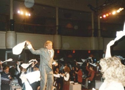 Man in black and white holding Redken product.